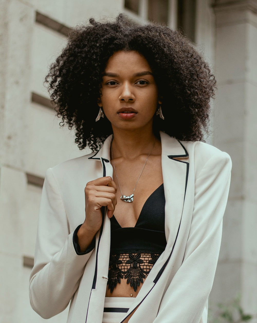 Young, urban professional woman wearing a unique pendant necklace with matching earrings.